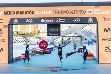 The clock is a second off but the smile says it all: Kibowott Kandie shatters the world half marathon record in Valencia (Organisers)